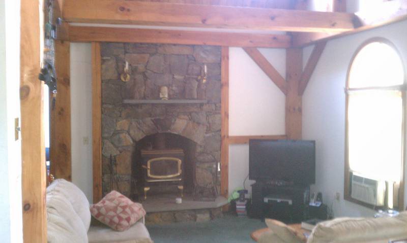 Fieldstone Fireplace with Avalon inserted wood stove in living room. - 41 Priest Rd