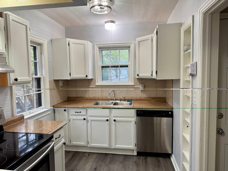 Bright kitchen with white cabinetry, dishwasher, and practical counter space. - 3682 Glencairn Road