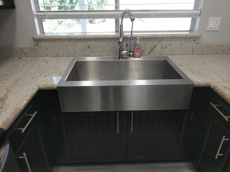 Stainless Steel front apron sink with commercial grade pull down contemporary pull down sprayer/faucet. East Wall - 14101 N 78th Dr
