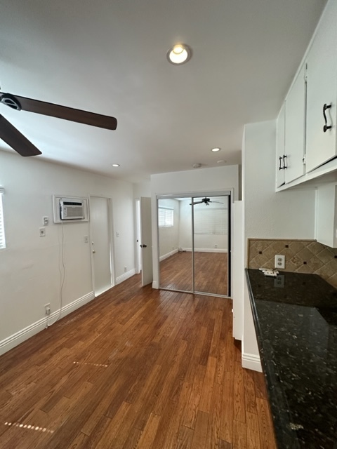 A close-up of the living room with wall, air conditioning, and mirror closet for extra storage and c - 5545 1/2 Allott Ave