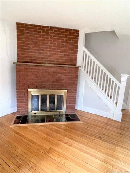 Hardwood floors and a decorative fp in the bright living room. - 10 Treadwell St
