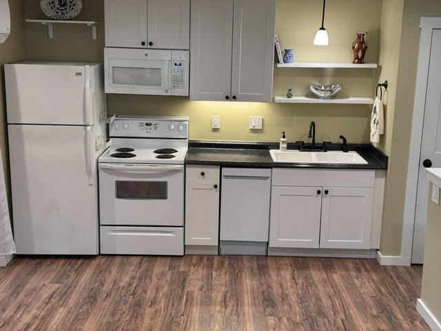 The kitchen includes a dishwasher, full-sized range, refrigerator, and microwave/ oven vent. - 9235 SW 7th Ave