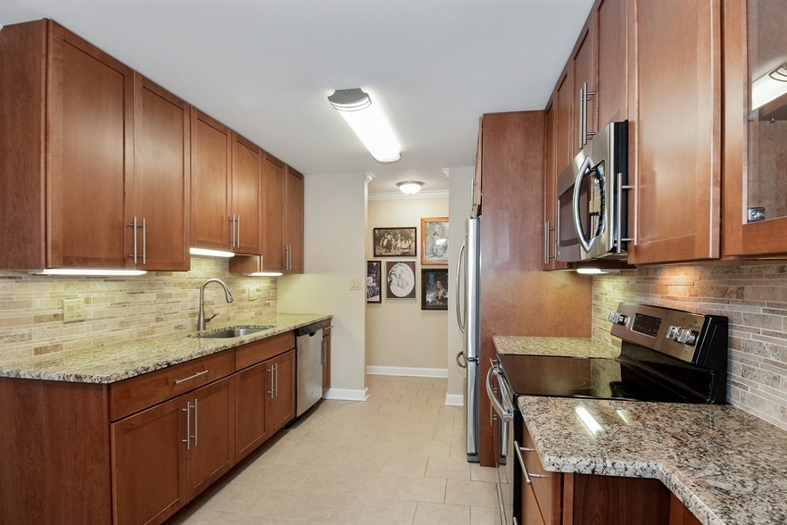 Spacious kitchen with Cherry Cabinets, Granite Countertops and Stainless Steel Appliances - Americana Apartments