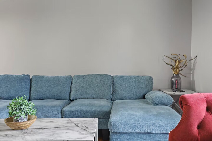 Living room with sleeper couch, smart TV and closet space. - 1002 Juniper Ln