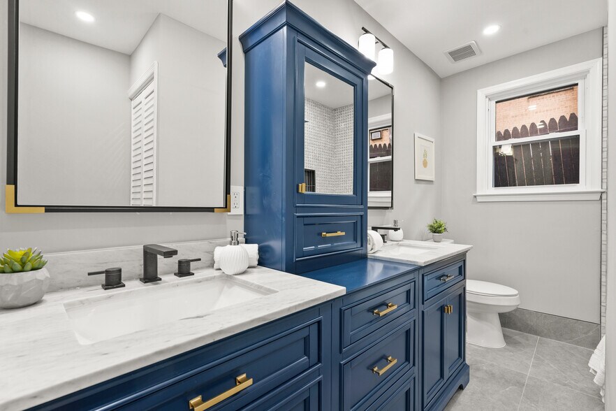 Primary bathroom with double vanity, tub, and toilet - 612 44th St NE