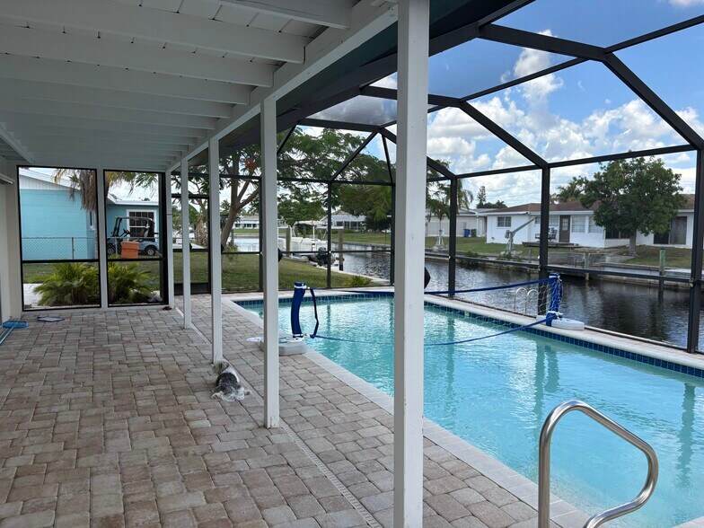 Plenty of covered patio space for your outdoor furniture. There is another patio outside the cage. - 4332 S Atlantic Cir