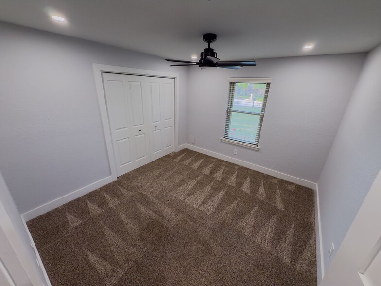 Bedroom with plush carpet, ceiling fan, and natural light - 2006 Candle Ct