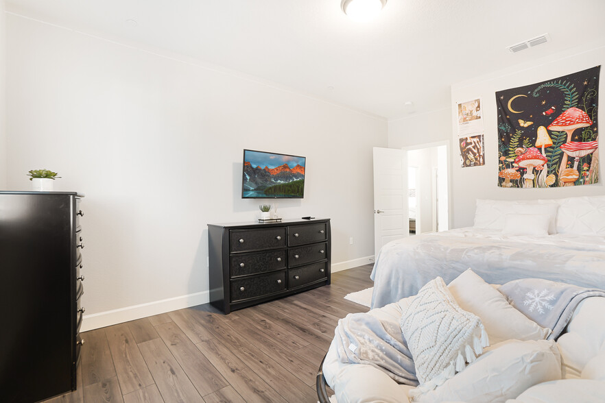 Large upstairs bedroom w/ walk-in closet (includes wall mounted TV w/ hidden wires behind wall). - 5919 Lakestone Dr