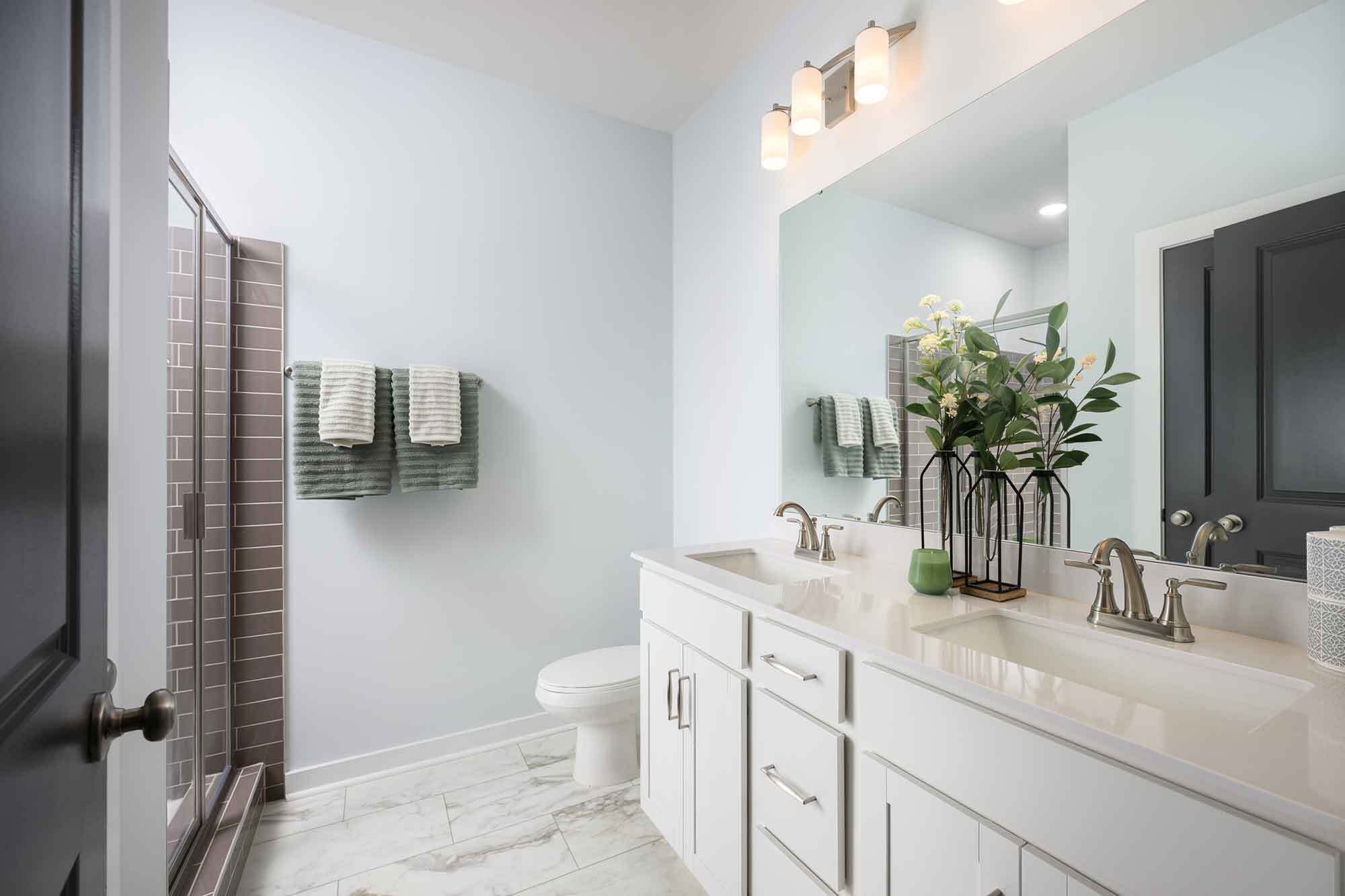 En-suite bath features dual vanities with quartz counters and an oversized walk-in shower - 1421 Lithium Ln