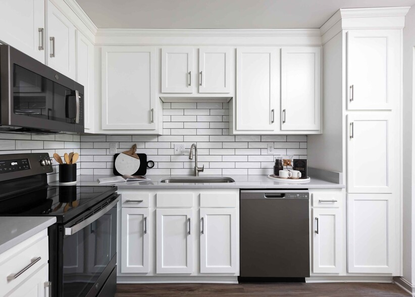 Modern kitchen with slate appliances and white cabinetry - Hurstbourne Grand Apartments