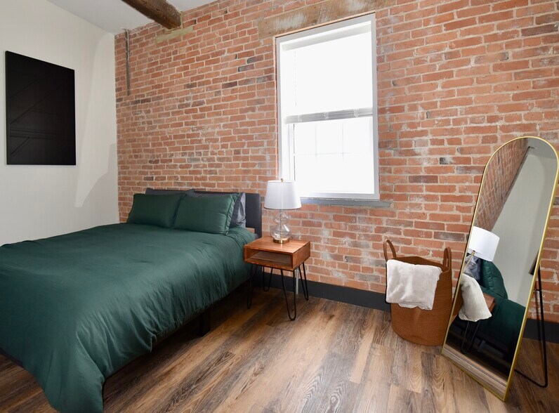 Guest/Second bedroom features a queen bed, smart TV, dresser and large closet - 101 W Broadway St