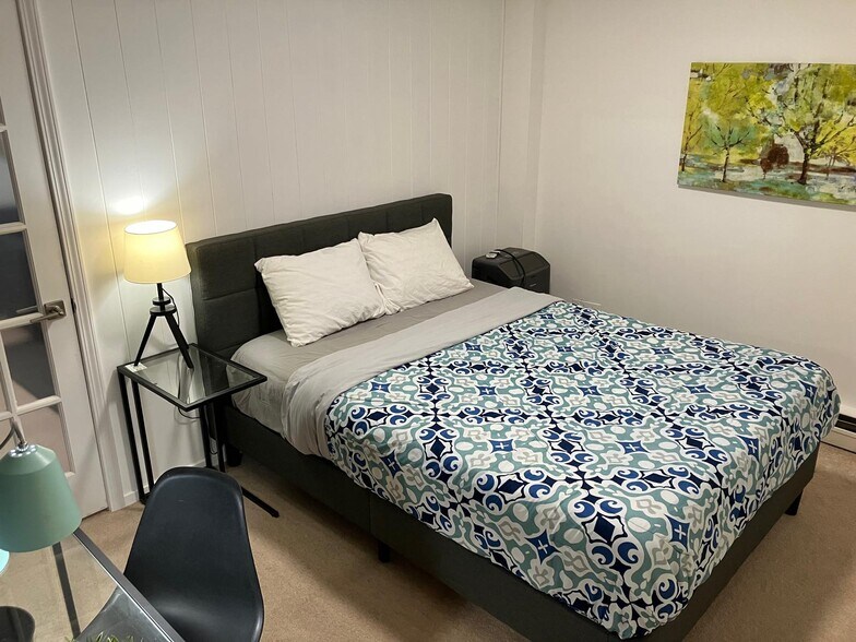 Second bedroom has queen bed, desk & chair for work, hanging rack for storage - 8200 E Jefferson Ave