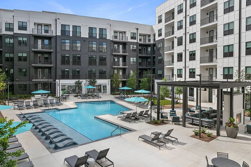 Resort-inspired saltwater pool with sun shelf &amp; grilling stations - Auden Apartments