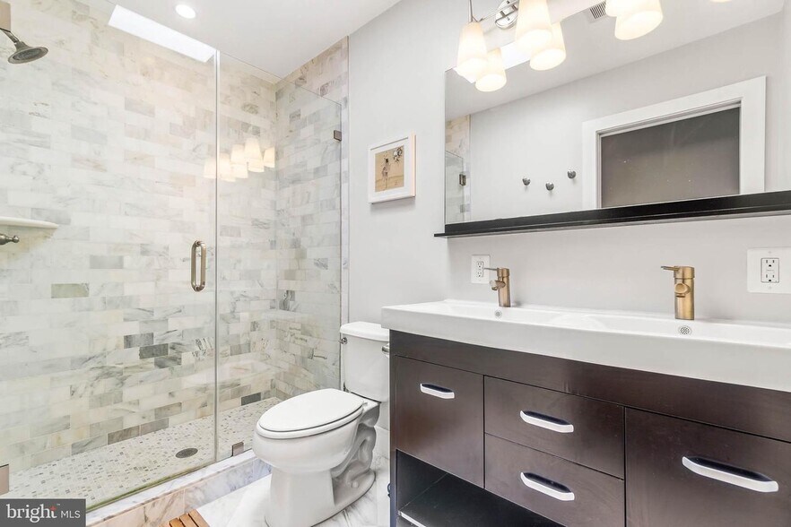 En suite primary bathroom with skylight to fill the room with natural light. - 3821 14th St NW