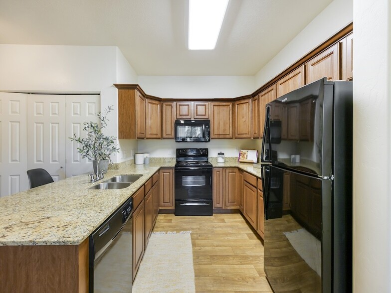 Kitchen with Black Appliances - Falls at Riverwoods Apartments and Townhomes