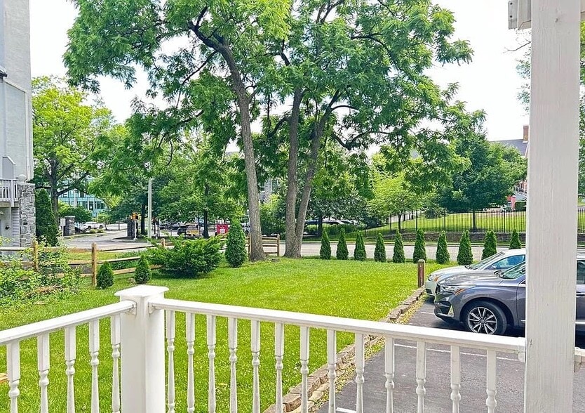 Enjoy the outdoors from the covered front porch overlooking a spacious shared yard. - 453 Lancaster Ave