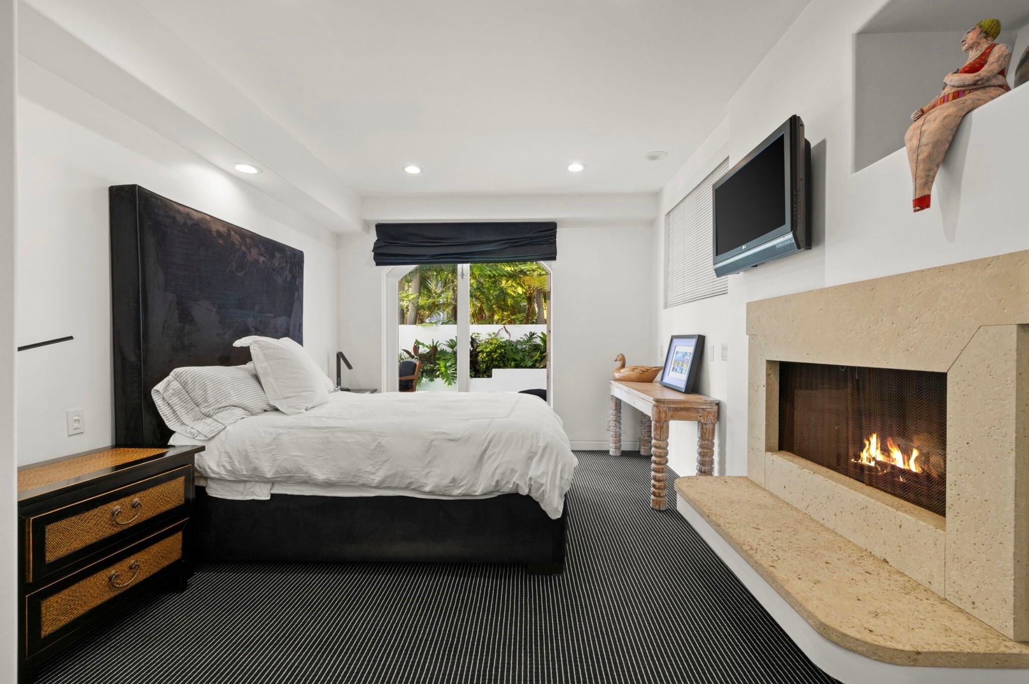 Guest bedroom features a gas fireplace and sliding glass doors opening to the lap pool deck area. - 120 Mast Mall