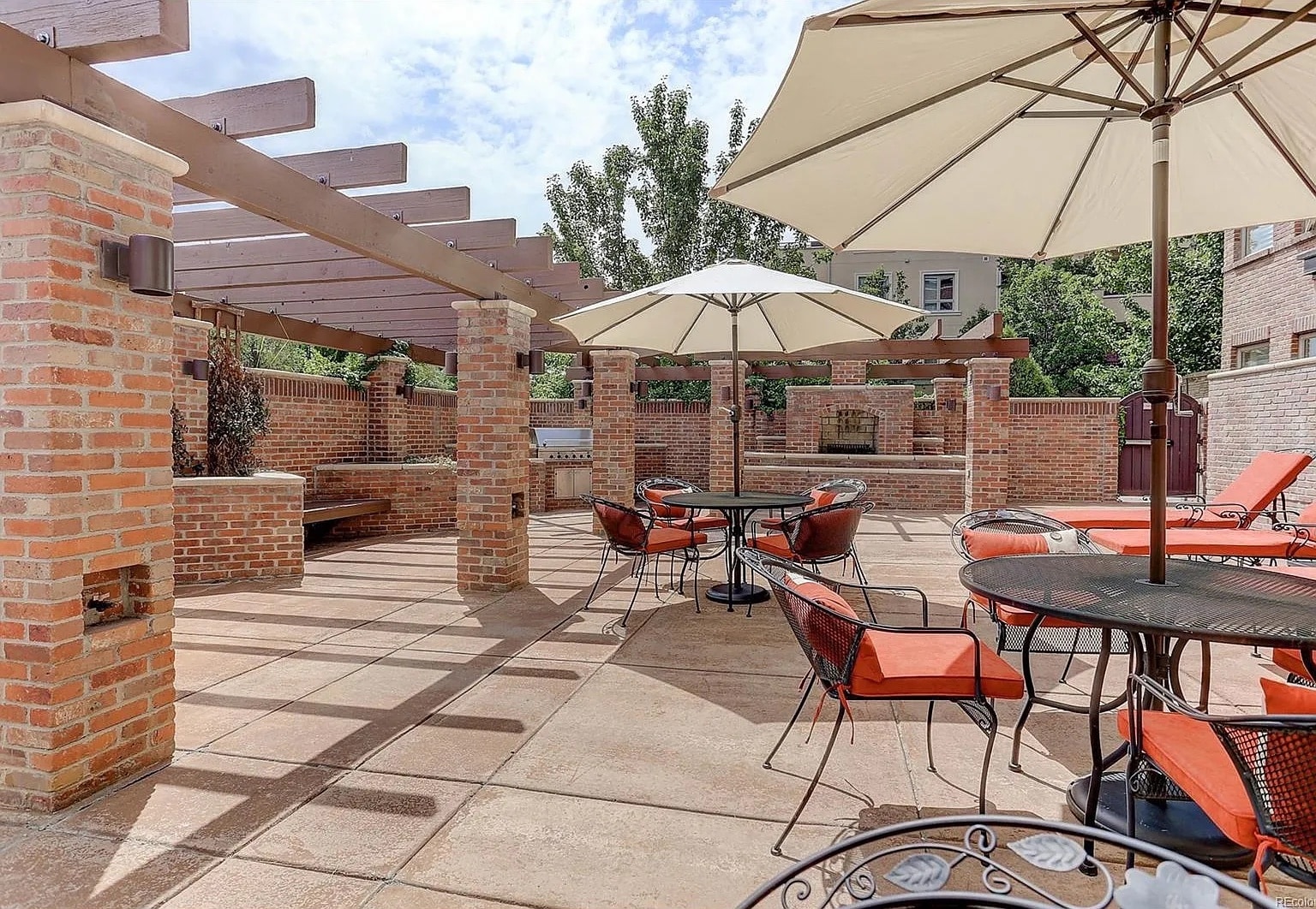 Communal patio with lounge chairs, tables, and grills - 2700 E Cherry Creek South Dr