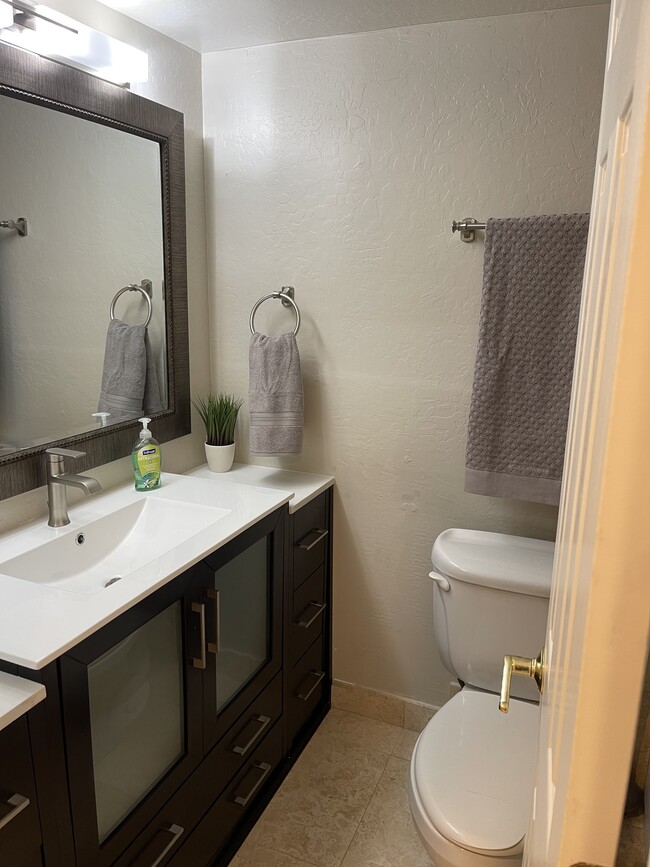 Bathroom 2, new vanities, travertine shower, tile throughout! - 4701 N 68th St