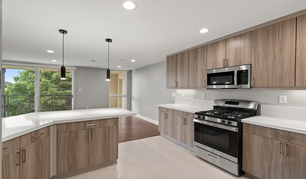 Designer kitchens with quartz countertops, stainless steel appliances and a breakfast bar - Preserve at Marin