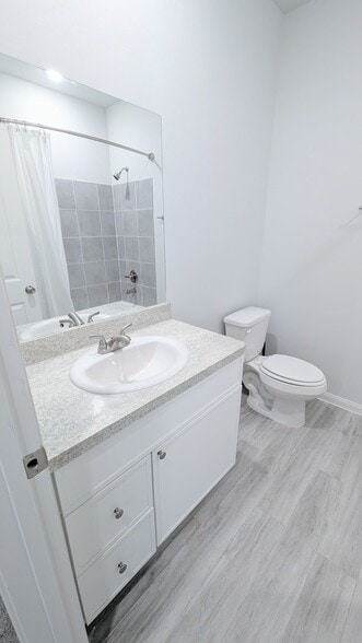 A large mirror and vinyl plank flooring keep this bathroom light and clean. - 13218 HP Johnson St