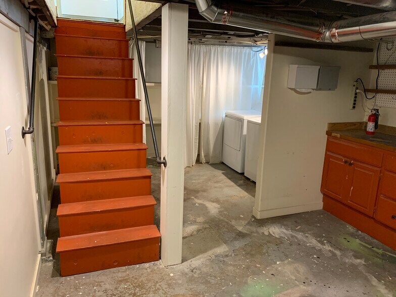 Basement stairs. Washer/dryer included. Storage shelves behind curtain and brand new hot water heater under stairs. Large workspace to the right for the craftspeople. - 5726 North Montana Avenue