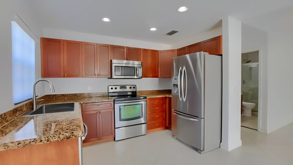 Remodeled kitchen with huge farmhouse sink, granite and wood cabinets - 9441 Boca Gardens Cir S