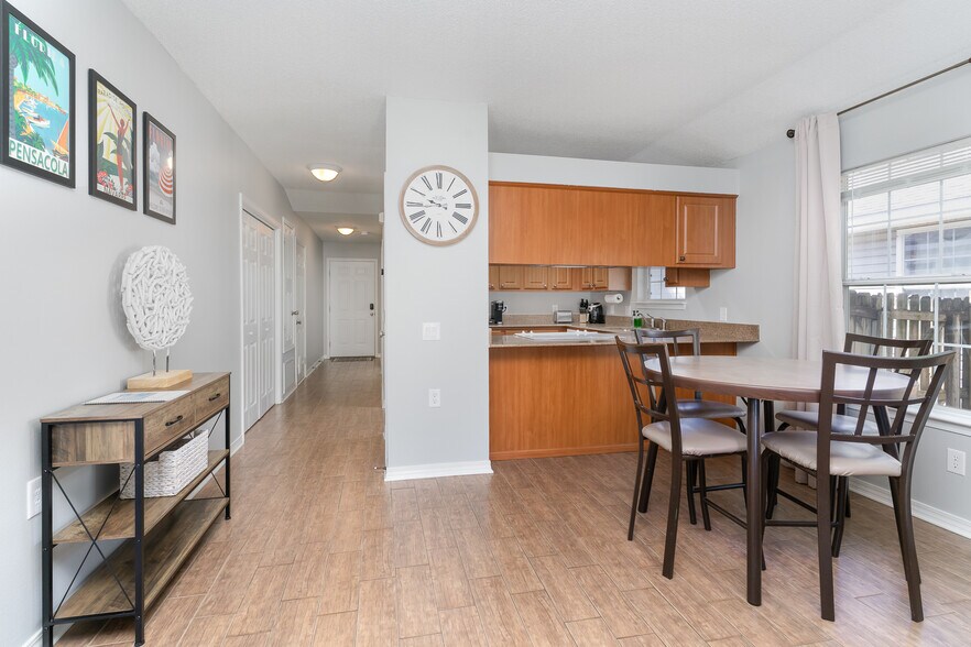 Open layout that let you see the kitchen and the living room with a dining table and 4 chairs. - 6464 Starfish Cv