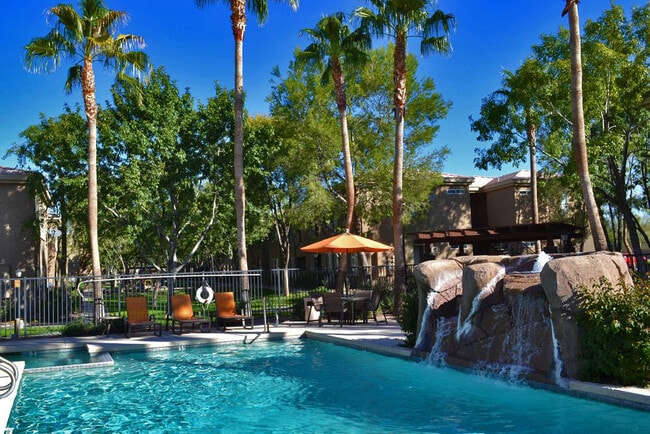 Glimmering Pool with Waterfall at Canyon Ridge - Canyon Ridge Apartments