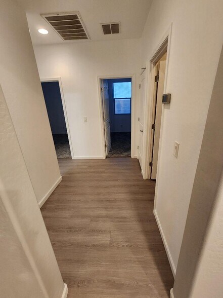 Hallway to two front bedrooms, bathroom, laundry room, and garage. - 40768 W Rio Grande Dr