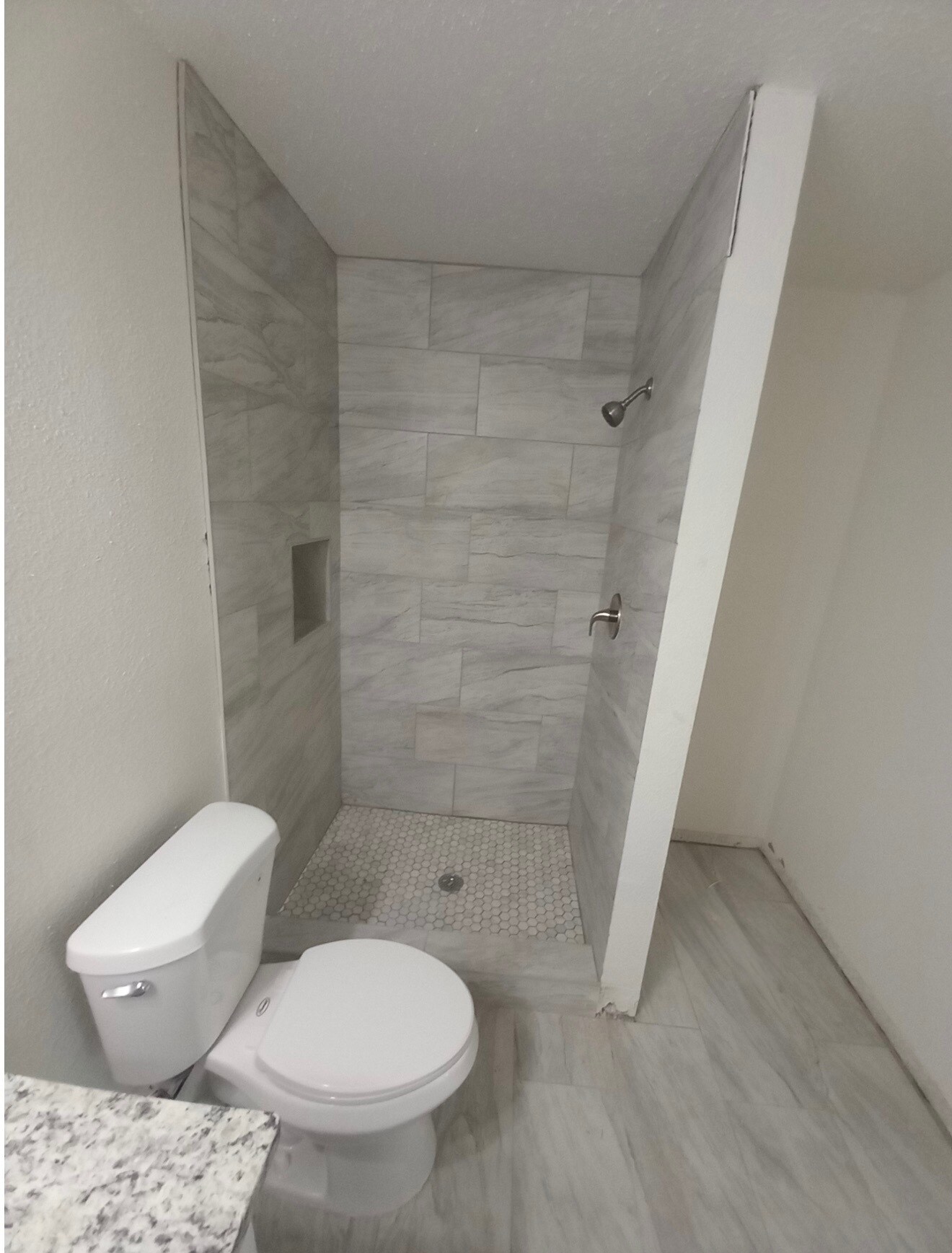 Close-up of shower with pebble-tile bottom. - 4720 Burma Rd