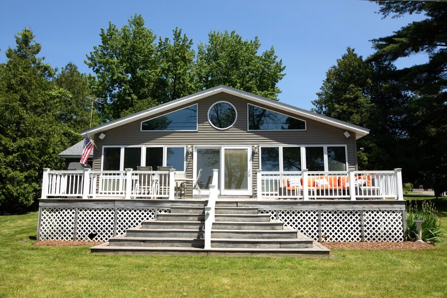 Front of the house with large deck, grill, table, and outdoor couch. - 6 Sandy Cv