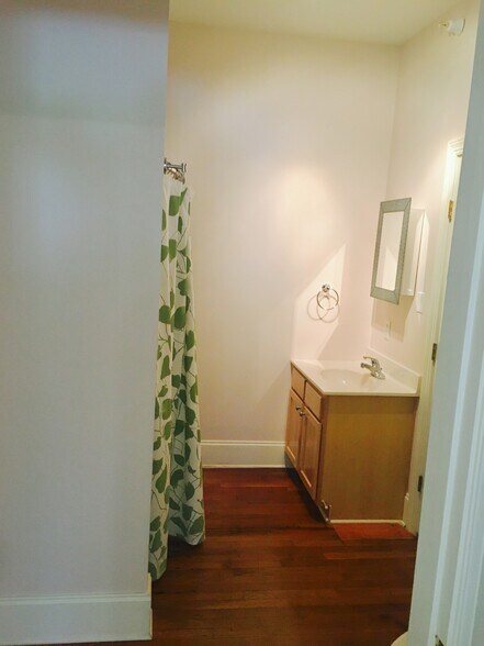 Full bathroom with tub, curved glass enclosure, and plenty of built-in storage space. - 1937 Fairfield Dr