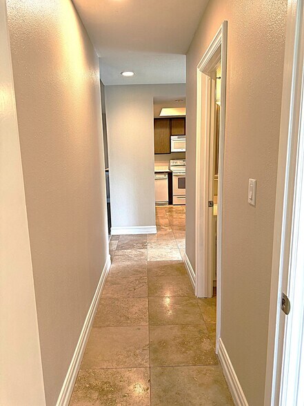 Hallway to bedroom two separated by the living room. - 545 S Ranch View Cir