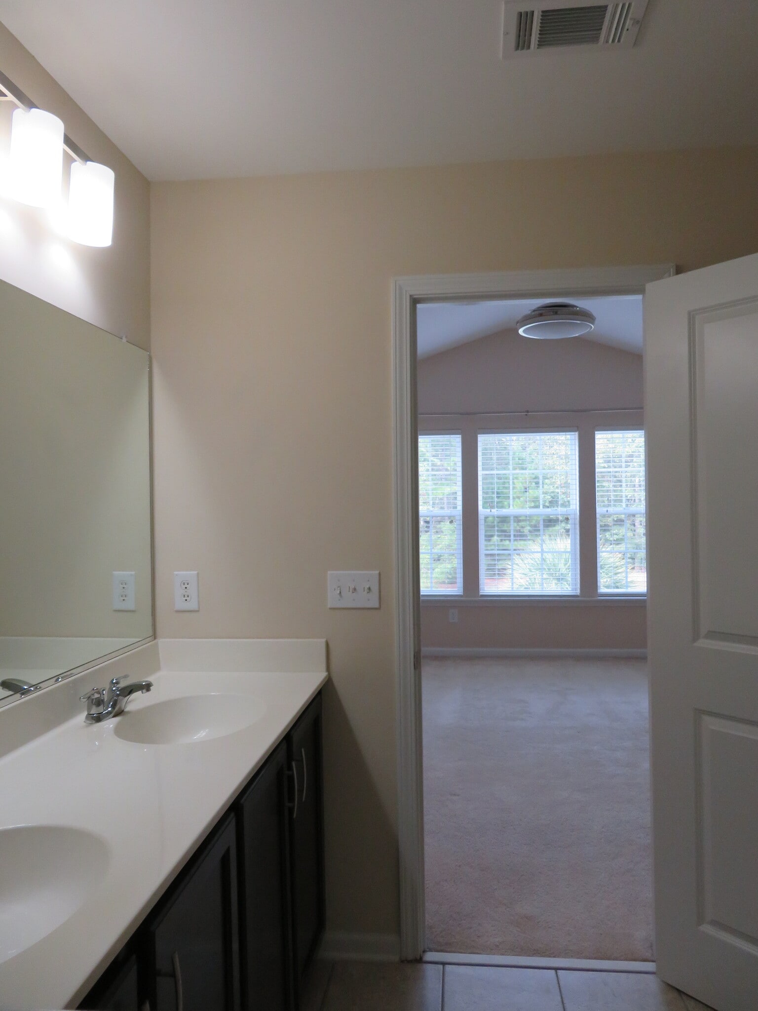 Master Bath w double sinks & upgraded lighting. View to Master Bedroom - 2496 Stadium Dr