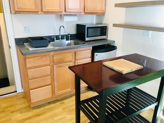 Kitchenette Showing Microwave Oven, Prep-Table, Fridge and Shelving - 2627 Manning Ave