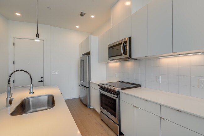 Kitchen - quartz countertops, stainless steel appliances, tile backsplash - 600 S Duke St