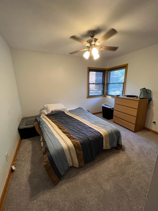 Main floor bedroom with new carpet and ceiling fan installed in 2022. - 1060 21st Ave SE