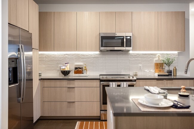 Modern kitchen with sleek finishes and stainless steel appliances. - The Allison at Fenton