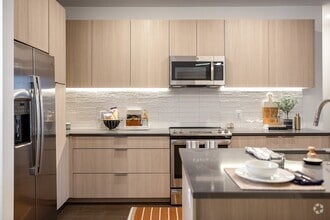 Modern kitchen with sleek finishes and stainless steel appliances. - The Allison at Fenton