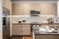 Modern kitchen with sleek finishes and stainless steel appliances. - The Allison at Fenton