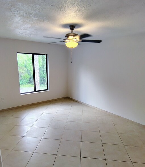 Main bedroom w/view of preserve; new ceiling fan - 1353 Pine Ridge Cir E