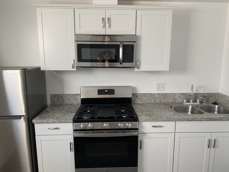Studio kitchen features granite counter tops, full gas range, microwave, and fridge. - 1911 W 94th St