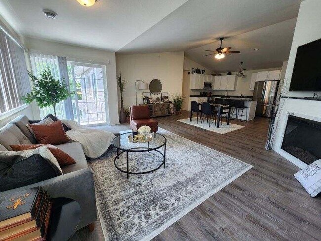 Large open concept apartment featuring fireplace in living room, balcony, dining area & kitchen. - Trail View Village Apartments
