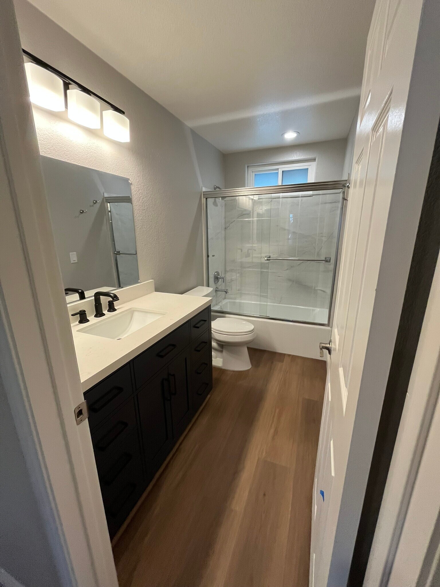 Hallway bath with beautiful new navy blue vanity with quartz countertop - 16274 Avenida Venusto