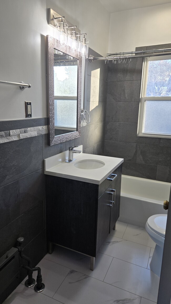 Looking into gorgeous bathroom. The vent fan/light above shower has a Bluetooth speaker built in! - 533 Smith Ave S