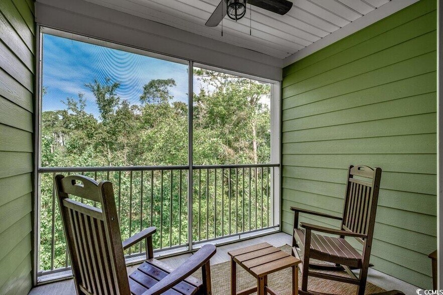 Screened in porch with ceiling fan overlooking wooded area. - 144 Puffin Dr