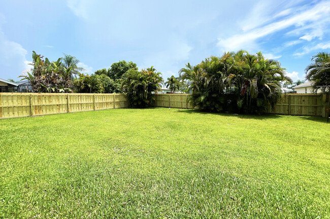 Spacious and fenced back yard with gorgeous palm trees - 722 SE Thanksgiving Ave