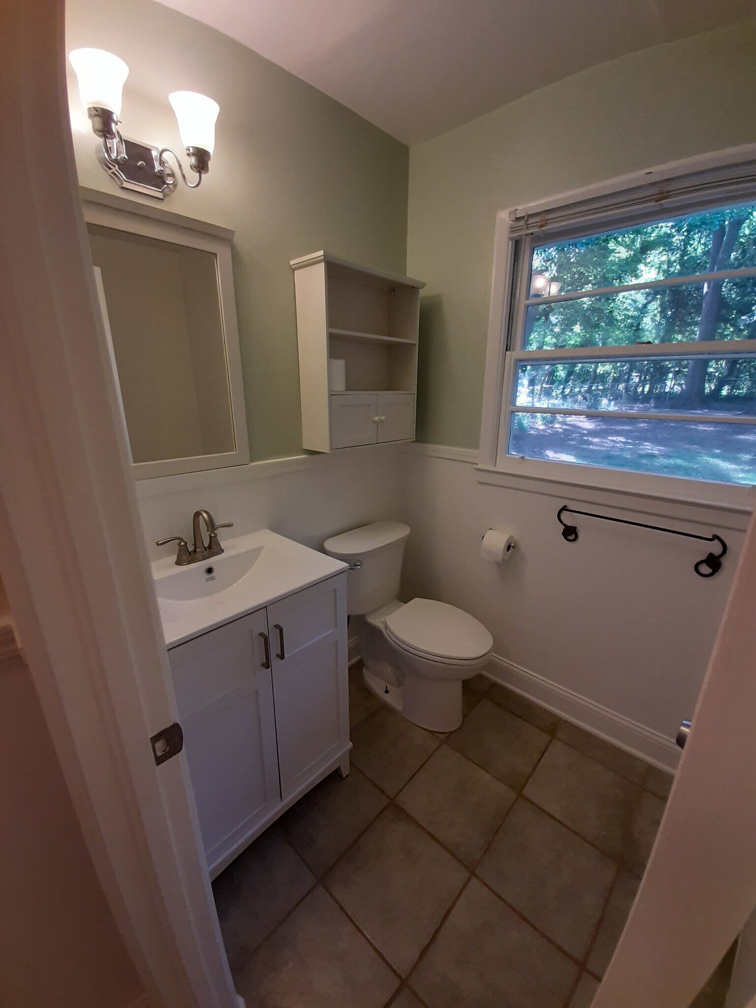 The full bathroom has a vanity, sink, and faucet, along with a backyard view. - 2955 Fantasy Ln