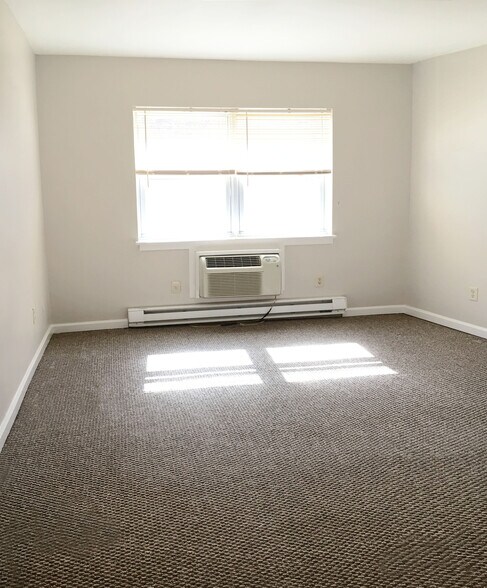 carpeted bedroom with ac unit and baseboard heating - 321 -323 Shore Dr